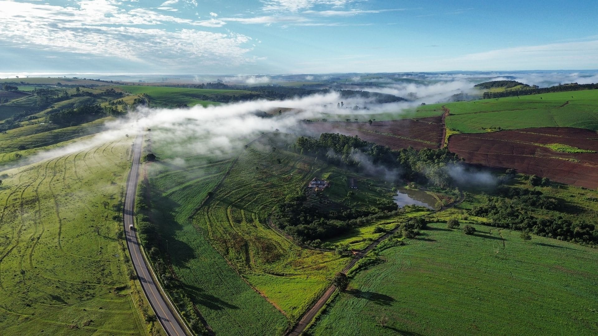 Aerial view of a green valley with morning mist