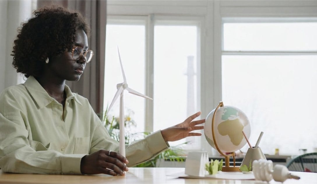 Professional with a globe and model wind turbine